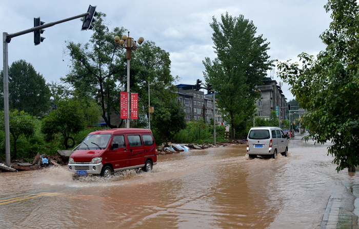 昭化城区部分路段积水，车辆小心通过.jpg